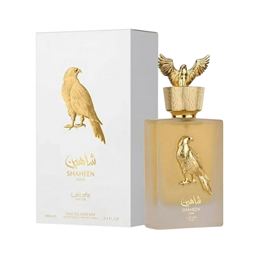 Perfume Shaheen Gold Original de BodegaPerfumera13 en frasco dorado con relieve de águila y caja blanca a juego.